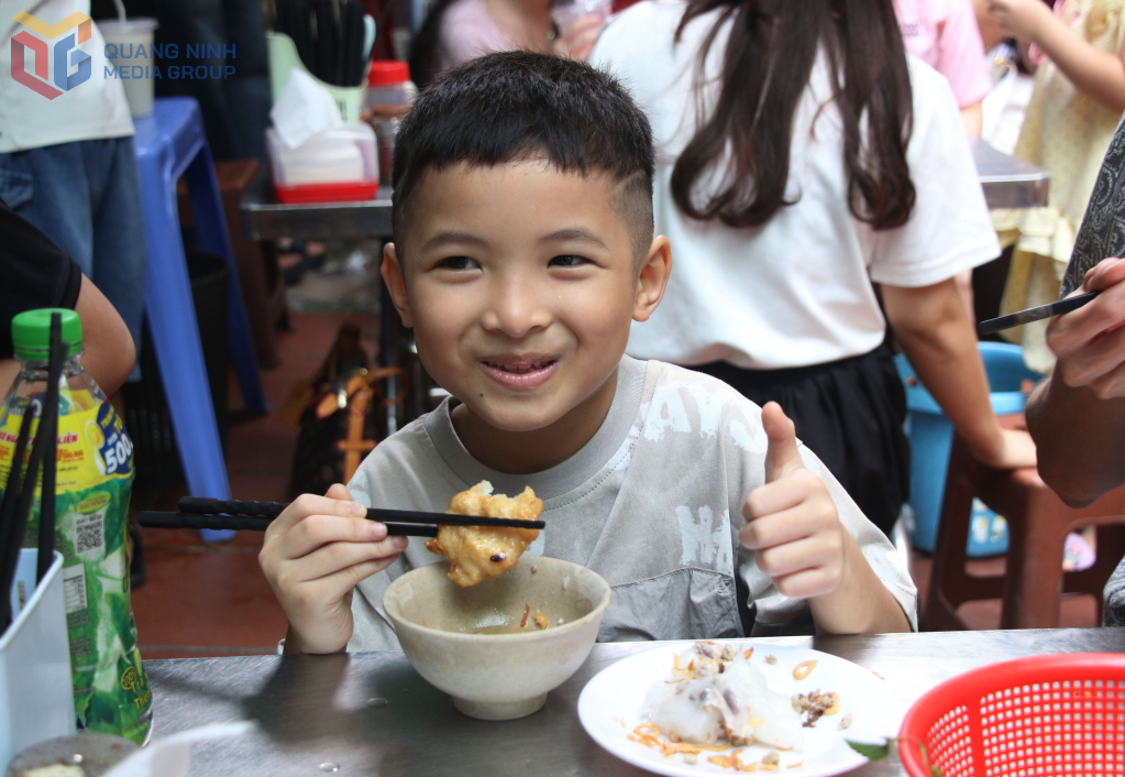 Em bé thích thú thưởng thức món bánh cuốn chả mực.
