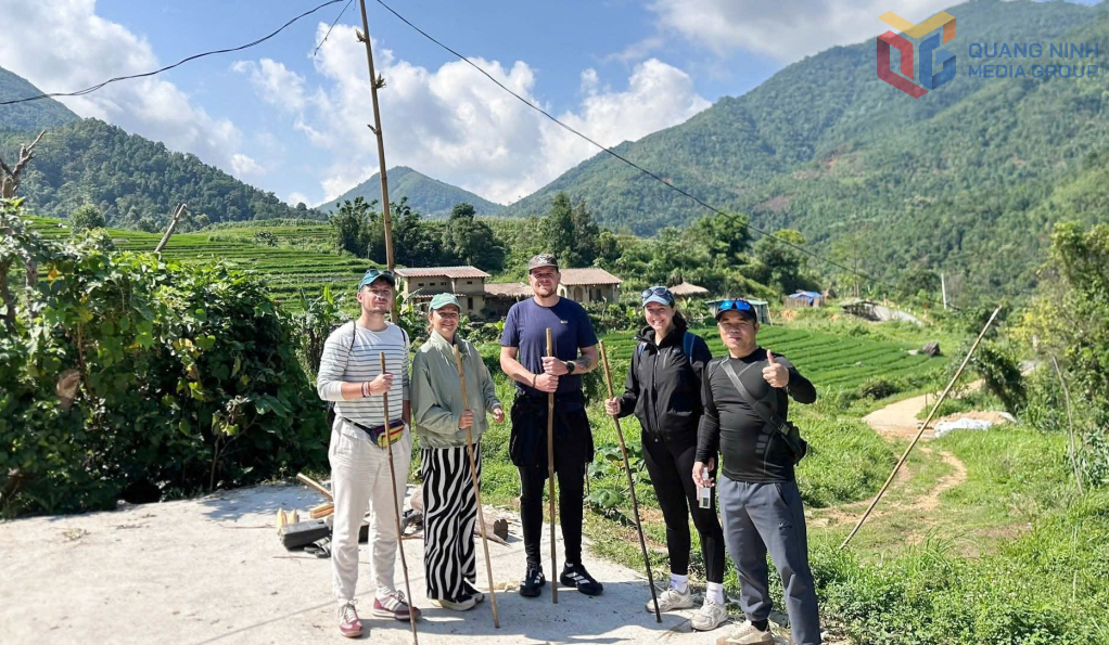 Anh Vi Lâm (ngoài cùng, bên phải) hướng dẫn viên du lịch đưa đoàn du khách Pháp trải nghiệm tại bản Sông Moóc xã Hoành Mô, tháng 4/2026.