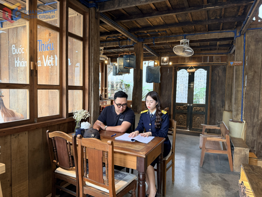 Cán bộ Thuế Cơ sở 1 hướng dẫn hộ kinh doanh ghi chép doanh thu. Ảnh: Cao Quỳnh